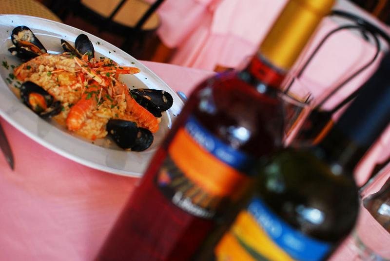 Risotto alla pescatora con bottiglie di vino